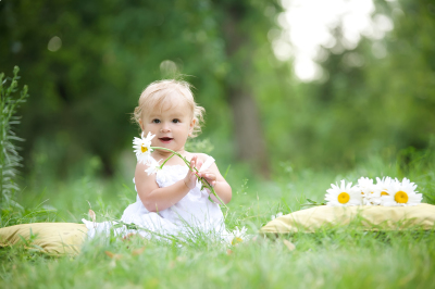 baby sitting on green grass